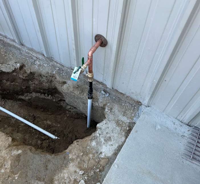 Professional installation of a new copper water line and shut-off valve emerging from a clean excavation site, highlighting the use of premium materials for long-lasting home reliability.