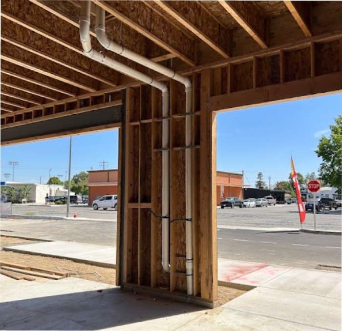 Expertly routed drainage and vent piping within a new commercial construction frame, showcasing the precision and clean organization that guarantees a reliable, leak-free foundation for your business.